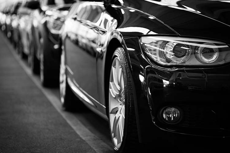 Une photo en noir et blanc d'une rangée de voitures.