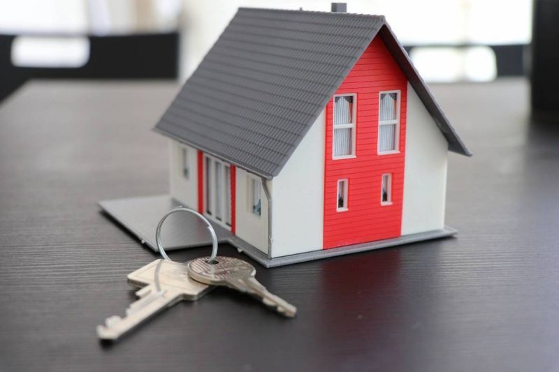 Une maison modèle avec des clés sur une table.
