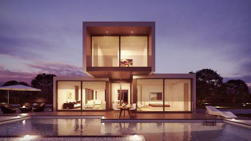 Une maison moderne avec une piscine au crépuscule.