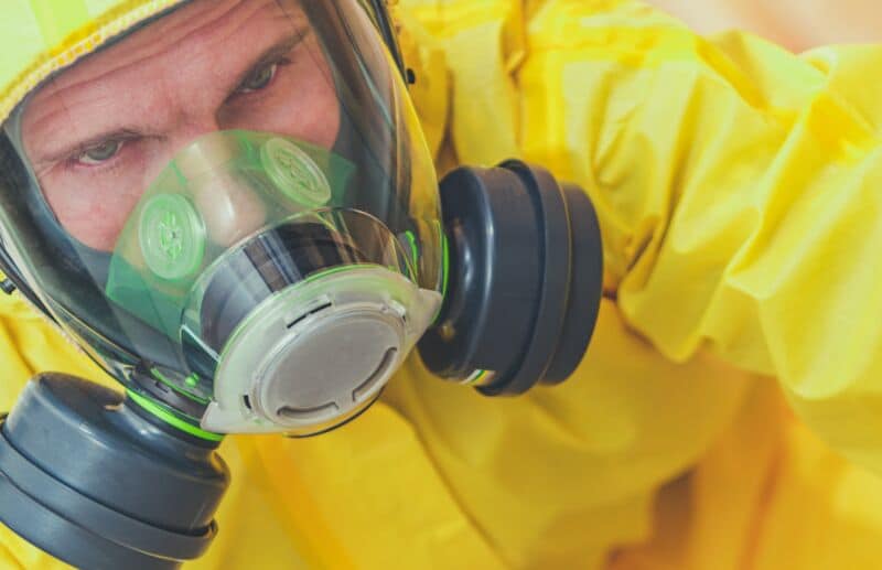 Tired Caucasian Worker in Hazmat Suit and Face Mask
