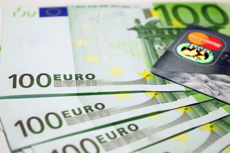 Billets en euros et carte de crédit sur fond blanc