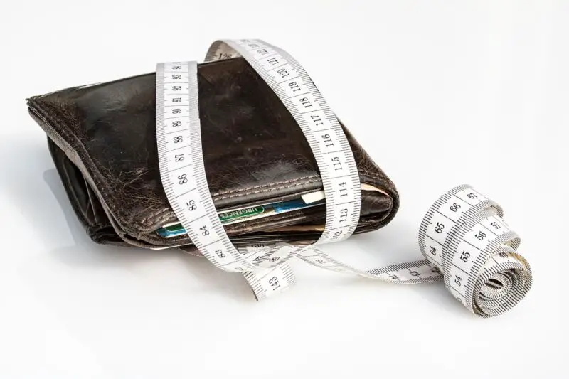 Un portefeuille avec un ruban à mesurer à côté