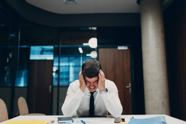 Un homme est assis à un bureau la tête sur la tête