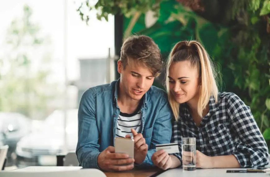 Un jeune couple regarde ses cartes de crédit dans un café