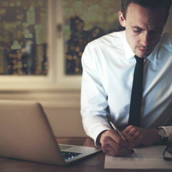 Un homme en costume d’affaires écrivant sur un ordinateur portable