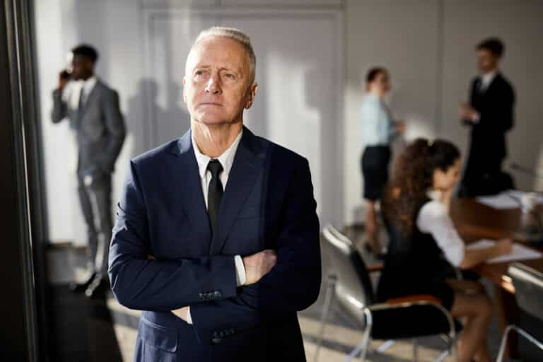 Un homme d’affaires en costume debout devant un groupe de personnes.