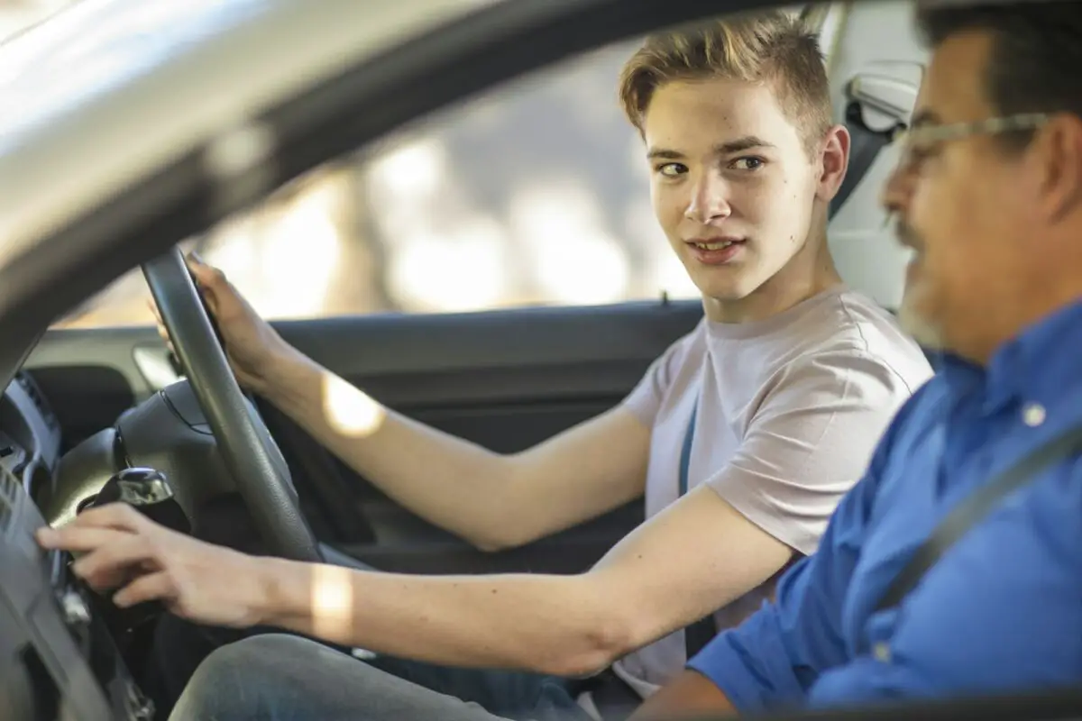 Un jeune homme conduit une voiture avec un homme plus âgé aux commandes
